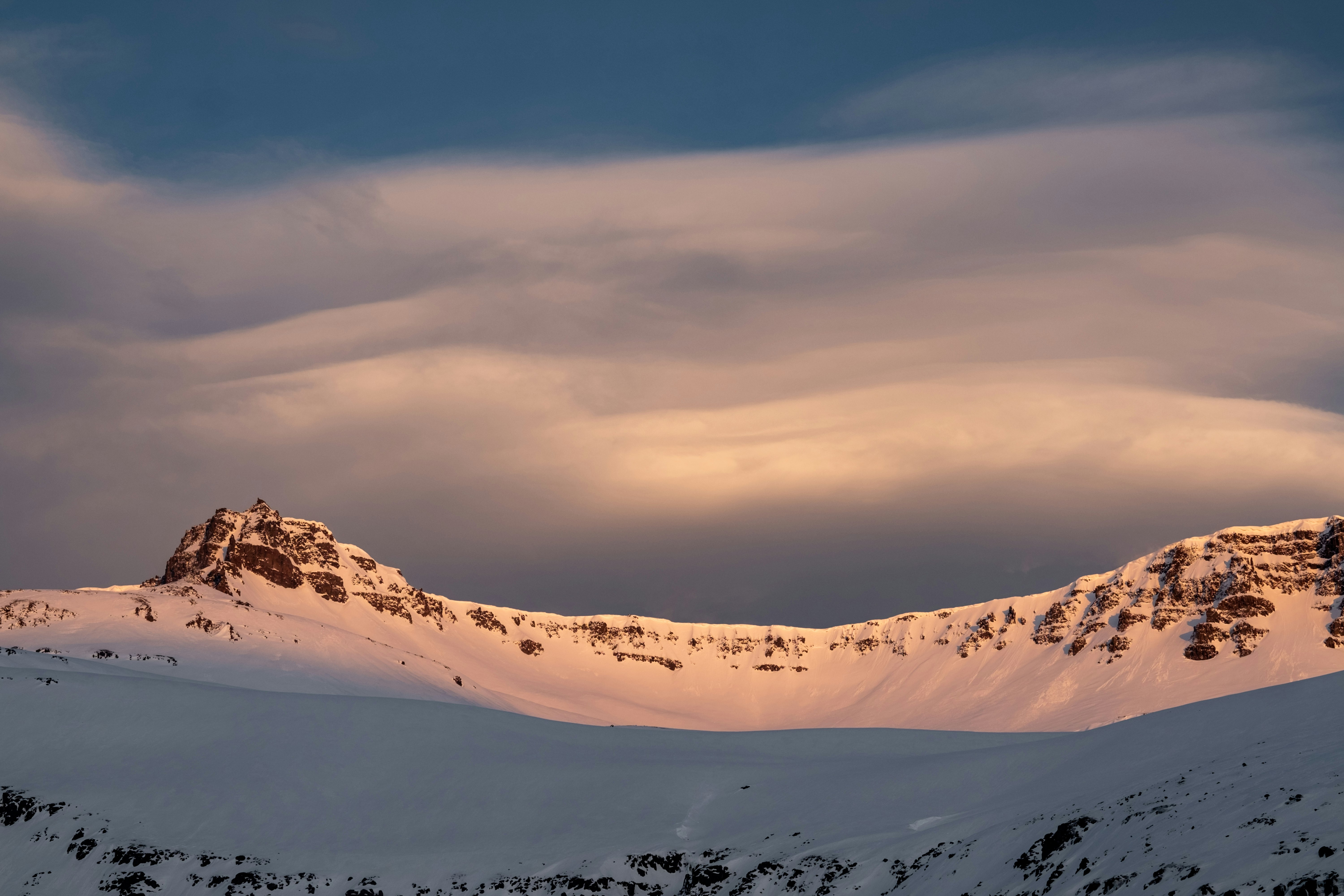 snow covered mountain under cloudy sky during daytime